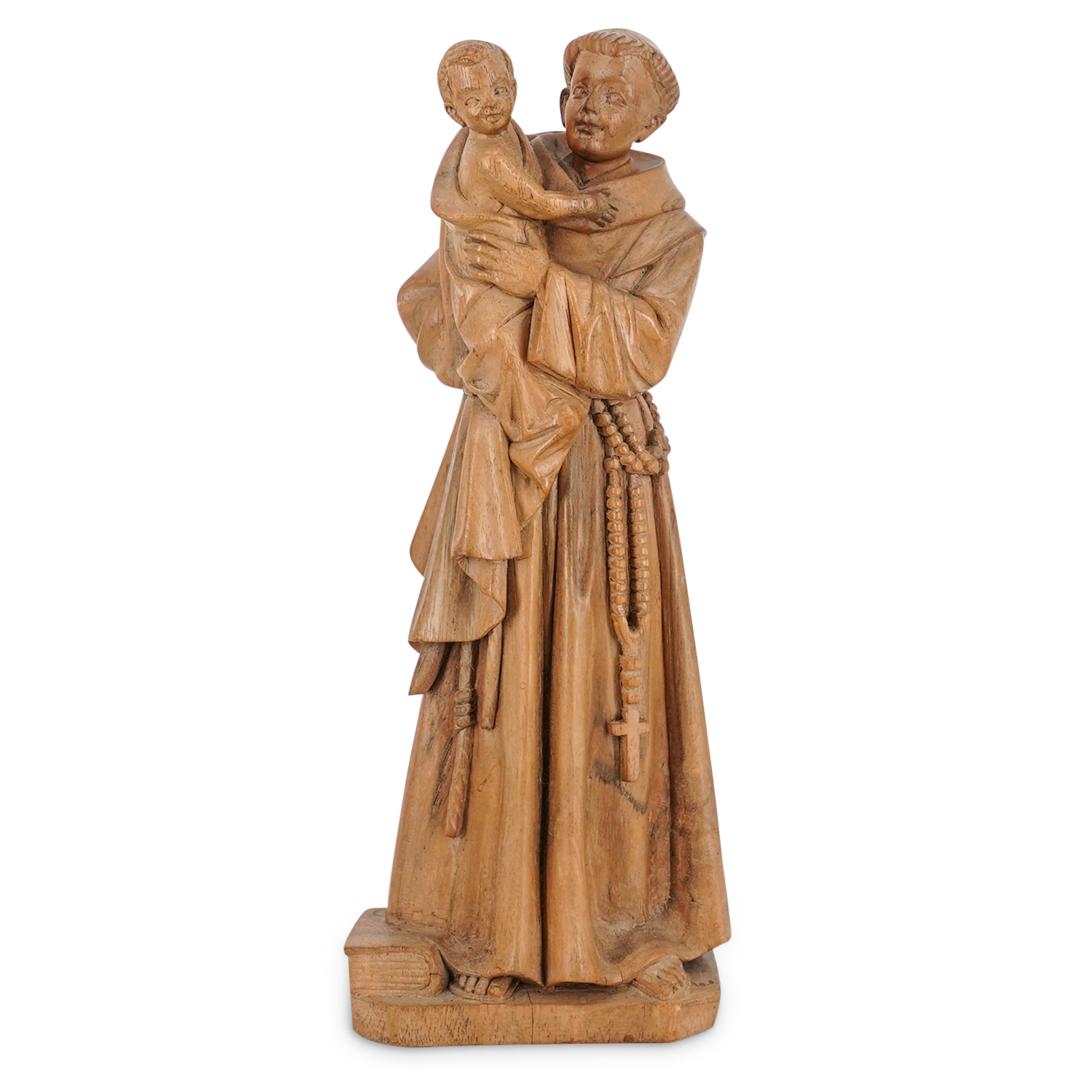 Carved Wood Saint Anthony Sculpture: DESCRIPTION: Carved wood sculpture of Saint Anthony of Padua wearing a rosary at his belt, standing next to a book, and holding the infant Christ. Figure stands on a wooden platform. CIRCA: 20th Centu