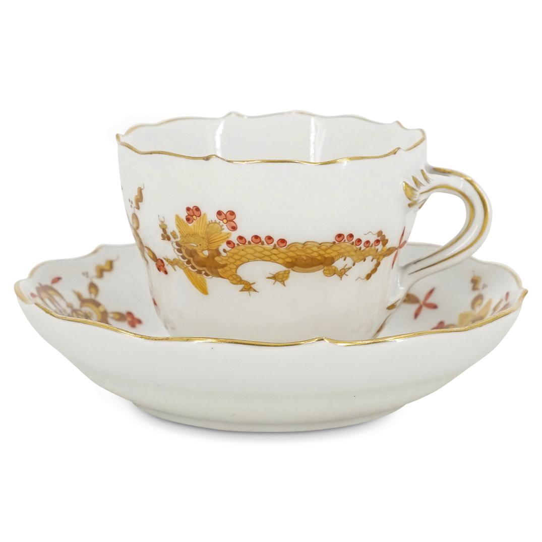 Antique Meissen Dragon Porcelain Cup and Saucer: DESCRIPTION: An antique Meissen Teacup and saucer features in a white ground, decorated with gilt dragon motifs with red accents, marked along the underside with double sword mark. CIRCA: 19th Cent. O
