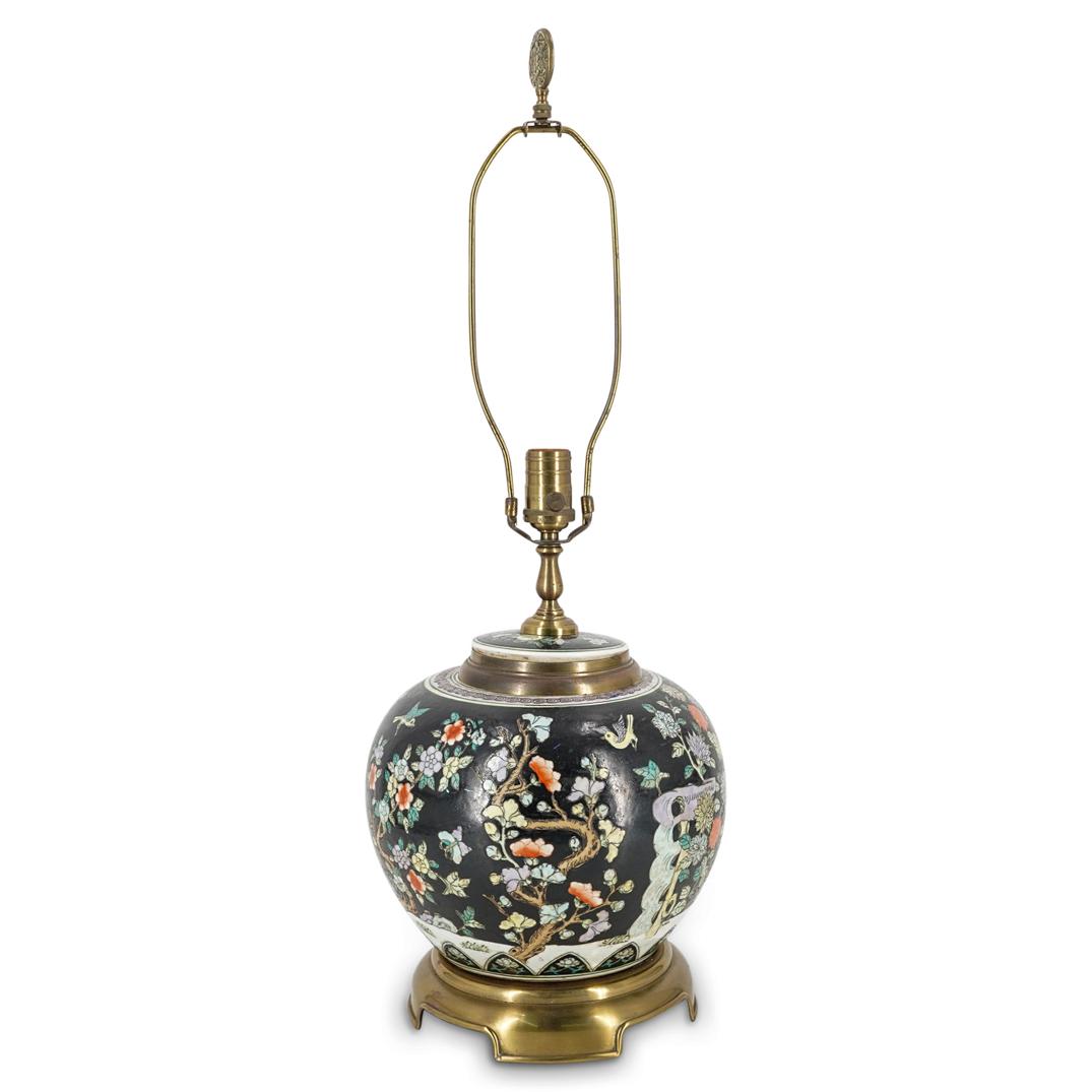 Chinese Famille Noire Porcelain Vase Lamp: DESCRIPTION: Famille noire vase converted to a table lamp. Vase depicts floral, avian, insect, and foliage motifs against a black background. Lid support and base are bronze; harp crowned with medalli
