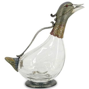 Italian Enameled Sterling Silver Duck Decanter: DESCRIPTION: Glass decanter shaped like a duck with highly detailed and enameled silver head, neck, handle, tail, and foot. Top half of duck's head opens on a hinge and beak is open for pouring.