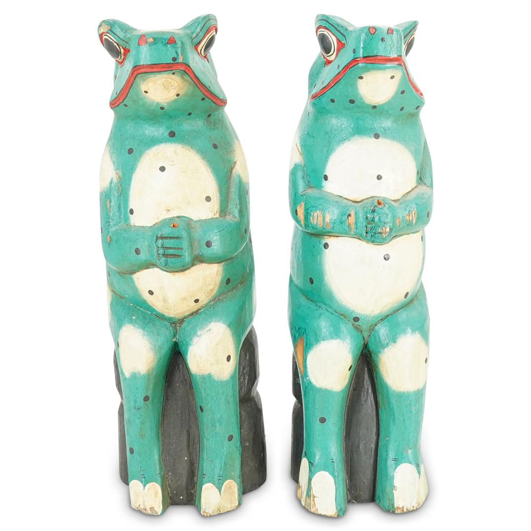 (2Pc) Pair of Carved Spotted Frogs Folk Art: DESCRIPTION: Pair of carved folk art green wood frogs painted with spots and red details in faces, sitting on black stumps. CIRCA: 20th Century ORIGIN: USA DIMENSIONS: H: 20" X W: 5" X L: 5.5" & H: 19