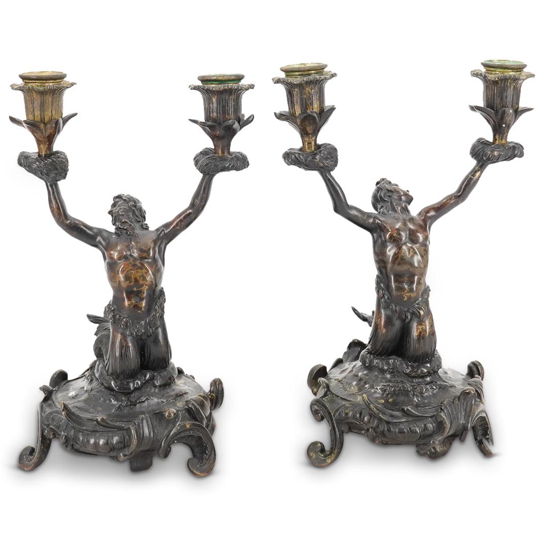 Pair of French Louis XIV Bronze Triton Candelabras: DESCRIPTION: Pair of antique French XIV patinated bronze candelabras, featuring figural Triton forms supporting double foliate designed, candle holding reservoirs. Finished with an ornate scrolling ba