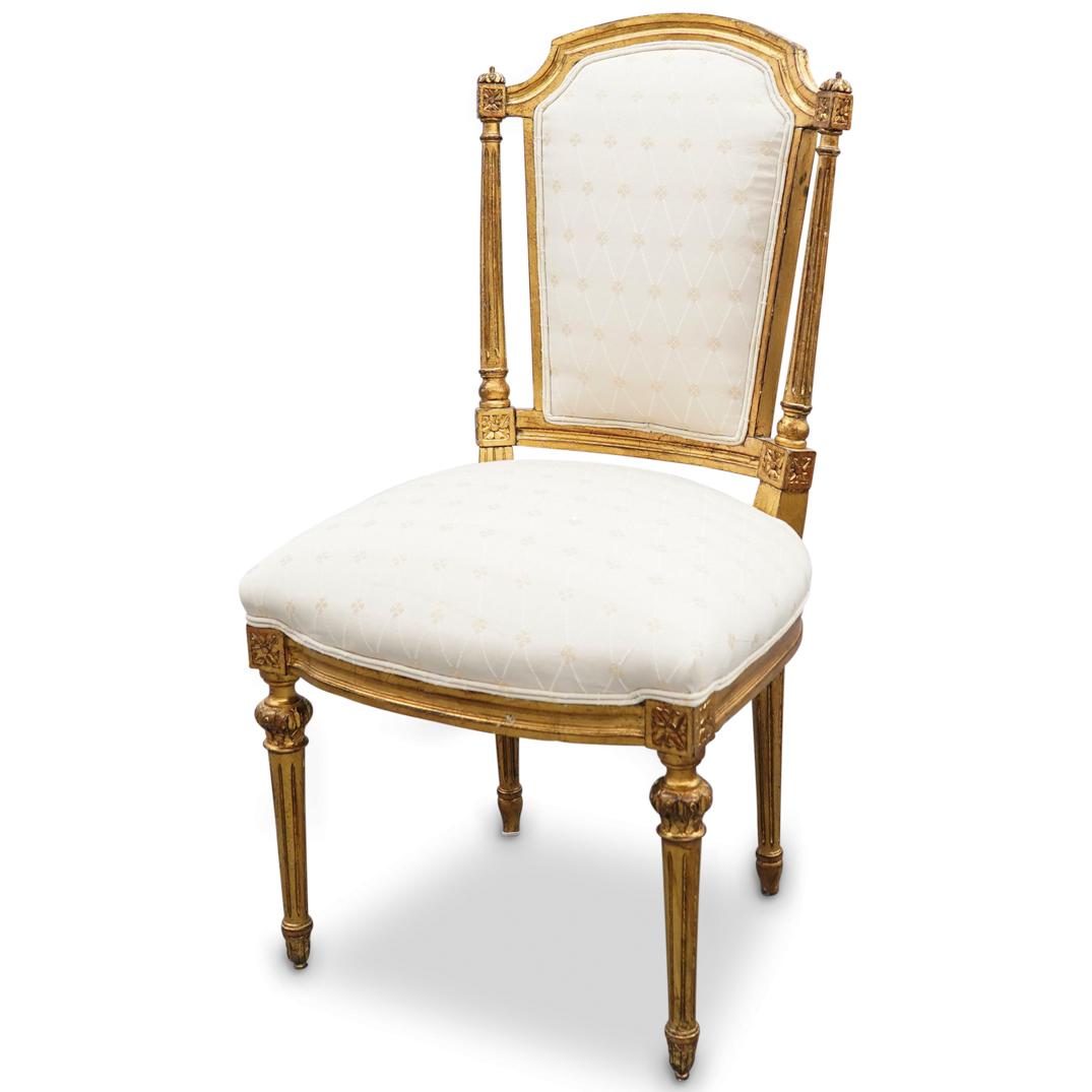Antique French Gilt Carved Chair: DESCRIPTION: An antique, French, Louis XVI style arm chair featuring a gilt carved wood foundation with foliate decorated silk upholstery. CIRCA: Early 20th Cent. ORIGIN: France DIMENSIONS: H: 39.5" x