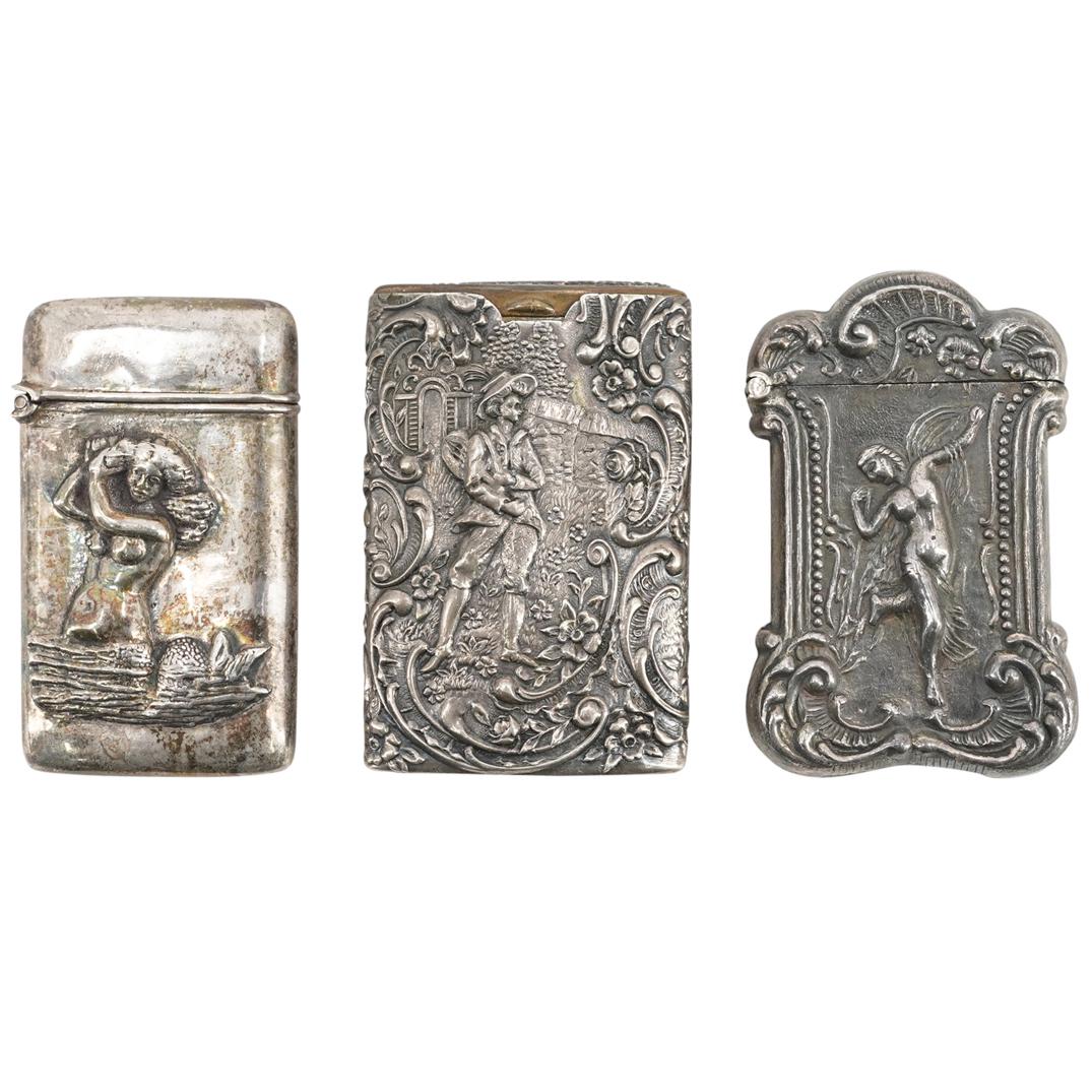 (3 Pc) Antique Sterling Silver Repousse Match Holder Case Set: DESCRIPTION: (3 Pc) A Sterling silver repousse antique matchstick holder case grouping set. These three vesta cases are decorated with figural repousse designs. One case depicts a pair of female and m
