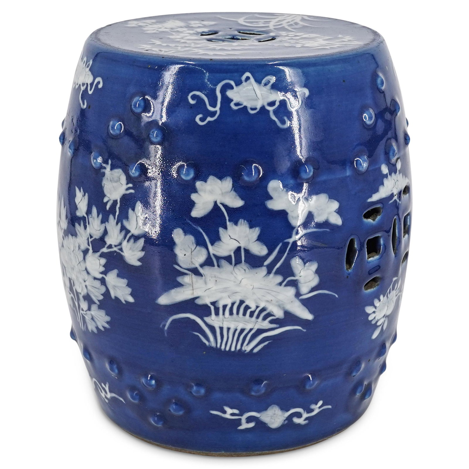 19th Century Chinese Blue & White Glazed Porcelain: DESCRIPTION: Glazed porcelain garden stool featuring white floral, foliage, curvilinear, and scroll motifs against a blue background and geometric reticulations on top and side. Piece is decorated wit