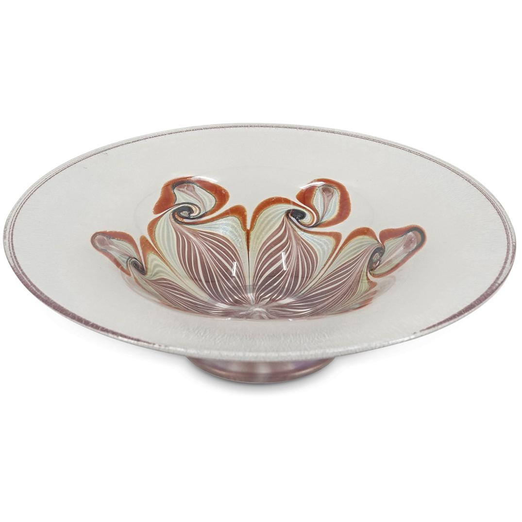 Vandermark Iridescent Glass Bowl 83/250: DESCRIPTION: Vandermark iridescent footed glass bowl, mulberry toned with swirling leaf designs moving out from the center. Etched signature at the underside "Vandermark 250/83". CIRCA: 20th Century O