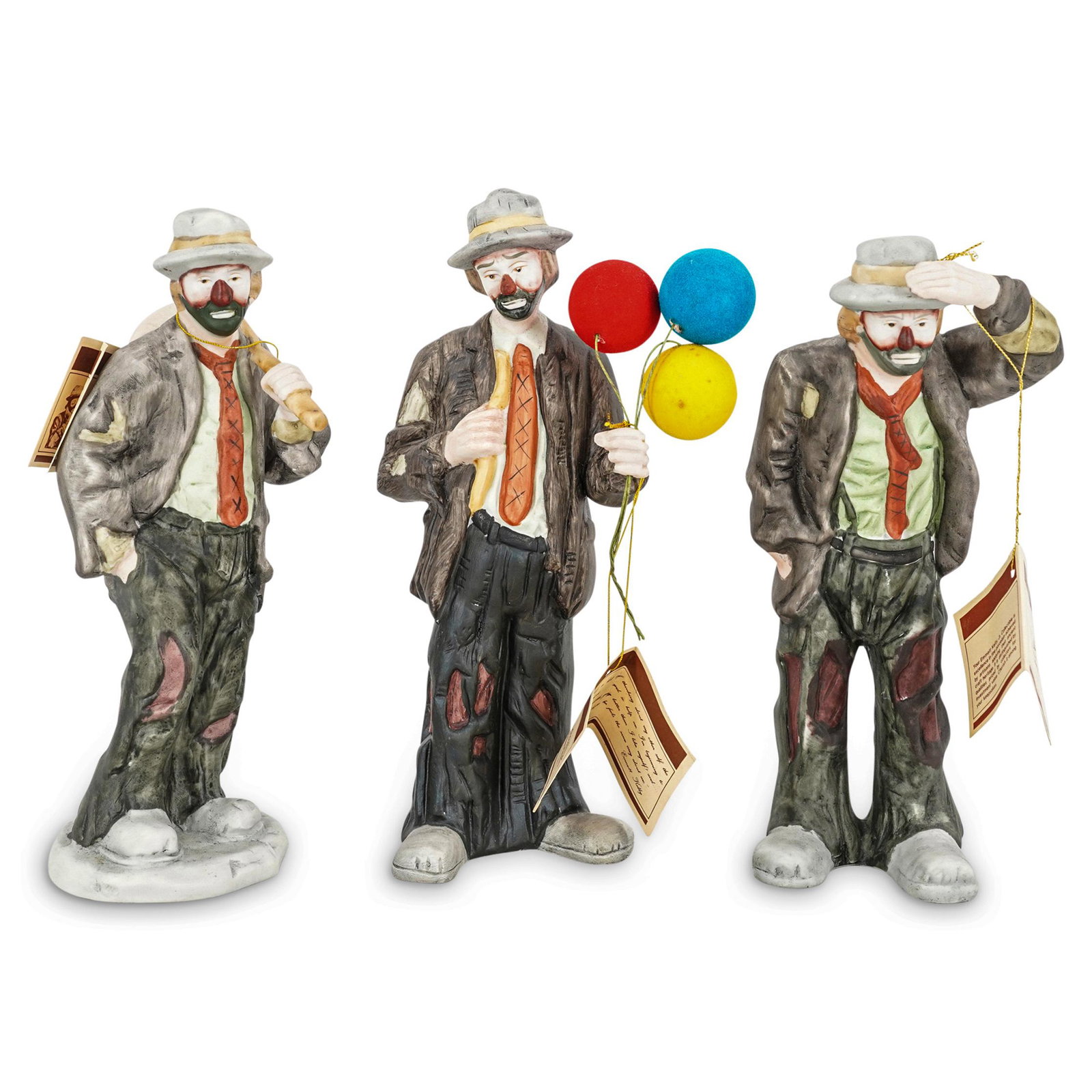(3 Pc) Emmett Kelly Flambro Porcelain Clown Figurines: DESCRIPTION: (3 Pc) A Emmett Kelly collectible porcelain clown figurines grouping set by Flambro. Emmett Leo Kelly was an American circus performer, who created the clown figure "Weary Willie," based 