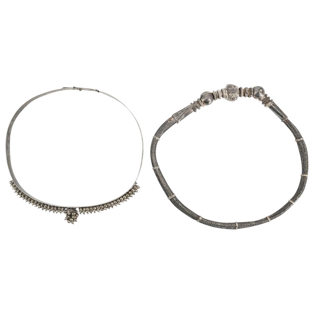 Pair Of Silver Belts: DESCRIPTION: Two silver belts: one with a corkscrew fastener with braided bands and one with a hole punch fastener with a solid flat band decorated with baubles. Hole punch fastener belt is hallmarked