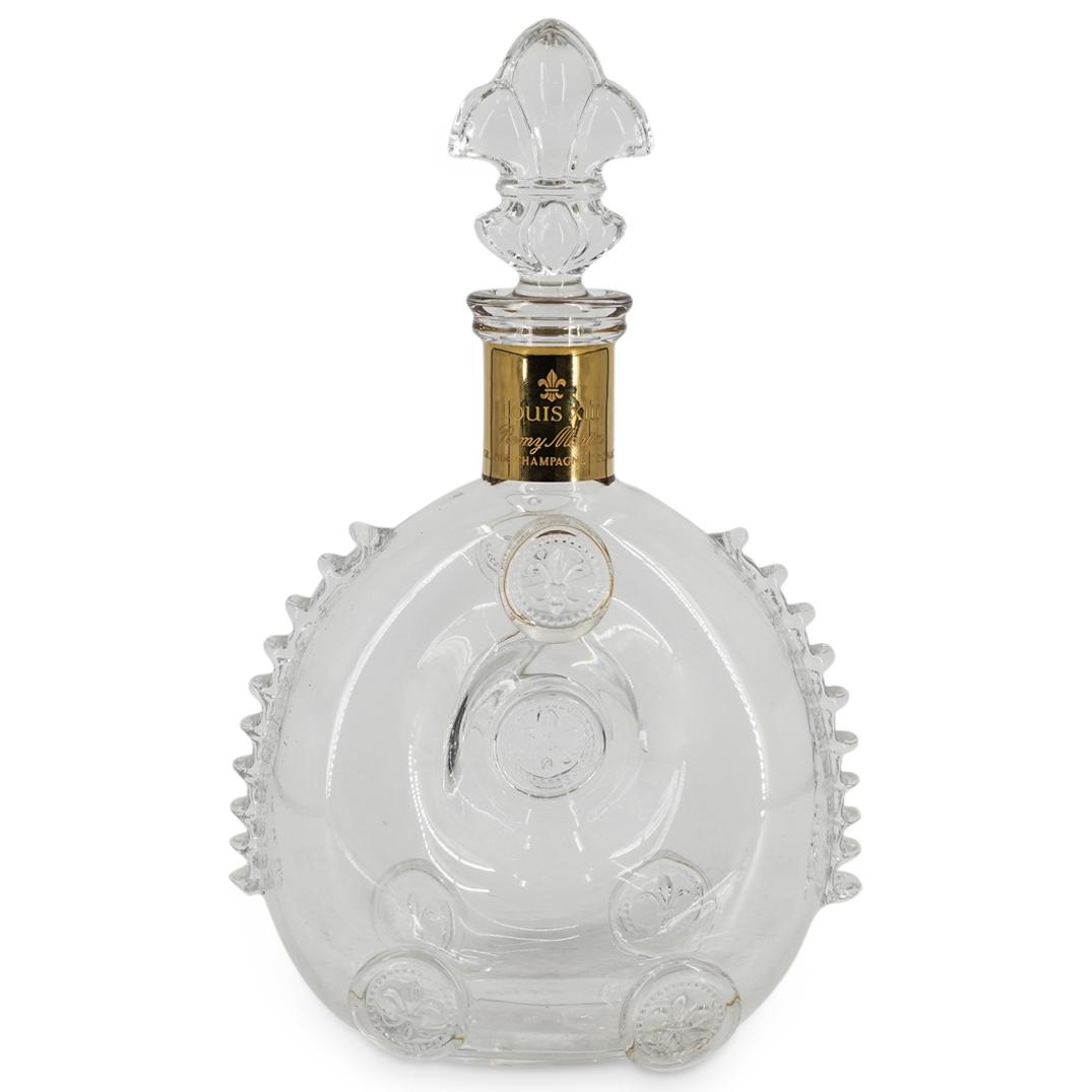 Remy Martin Louis XIII Baccarat Glass Decanter: DESCRIPTION: Remy Martin Louis XIII Baccarat glass decanter featuring a circular tube design decorated with trefoil medallion prunts on the front and back and ridges on its sides. Crowned with a trefo