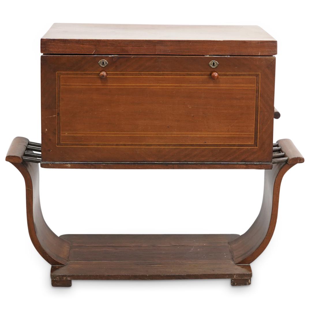 Parquetry Wooden Fold Out Cocktail Bar: DESCRIPTION: Wooden bar featuring a hinged lid, racks along the inside for small bottles, and a fold-out front with a glass inset decorated with a gilt geometric and foliage design. Sides, front, and 