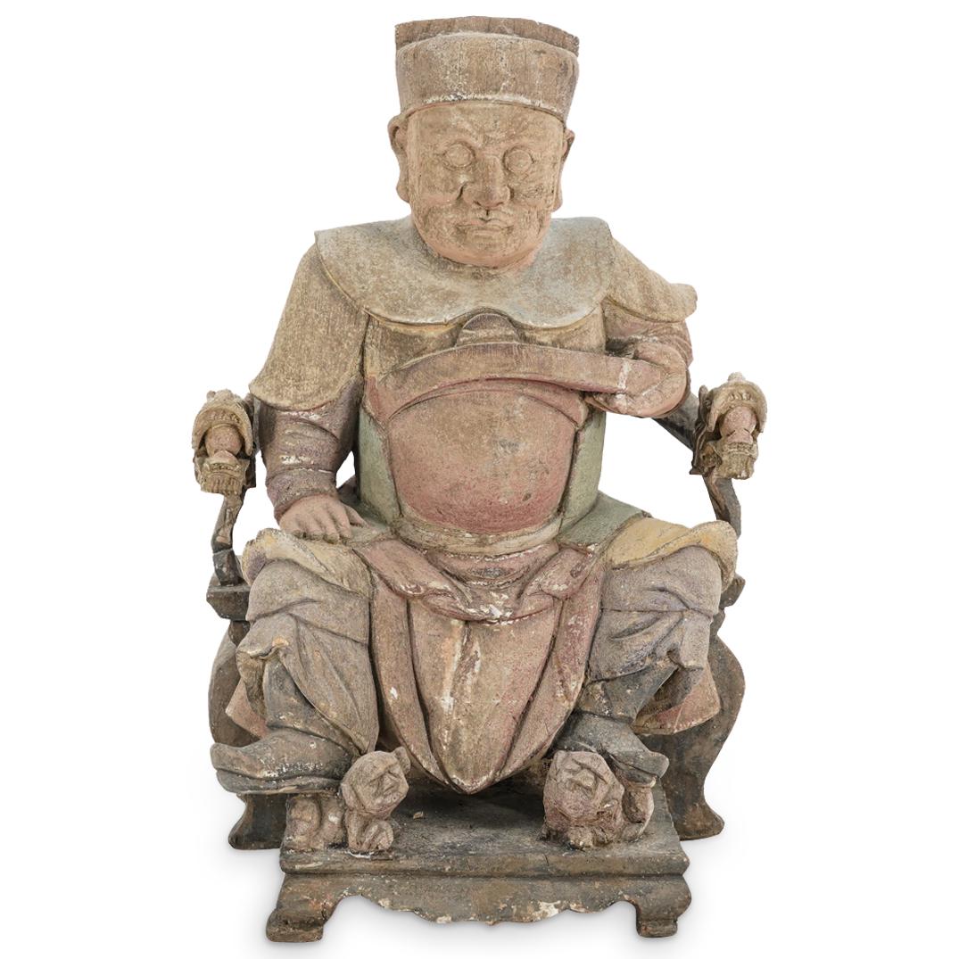 Chinese Patinated Carved Wood Sculpture Of Seated Emperor: DESCRIPTION: Patinated, carved wood sculpture depicting a sovereign seated in a chair featuring dragon form arms and resting each of his feet on a dog. Figure is of one piece with the chair. CIRCA: Ea