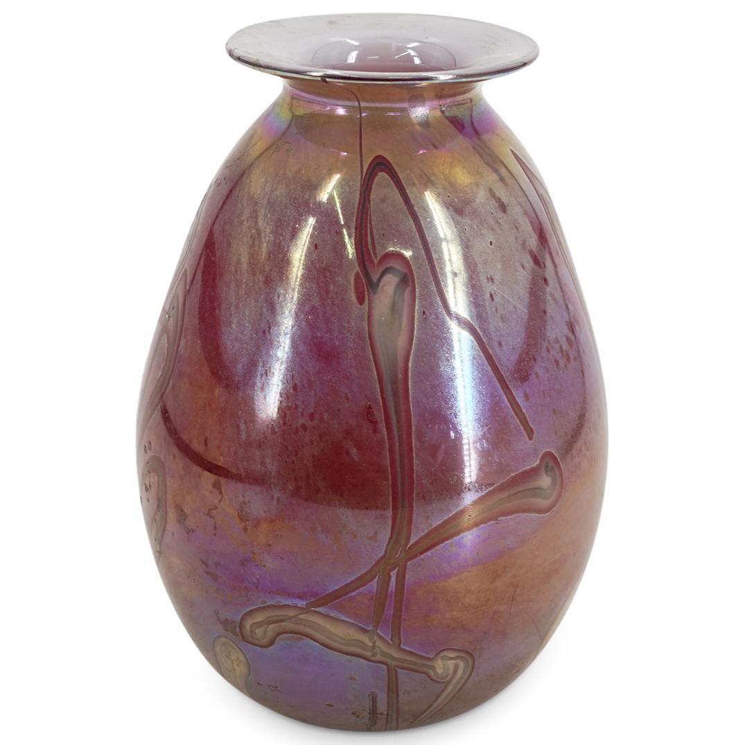 Iridescent Signed Art Glass Vase: DESCRIPTION: Signed art glass vase featuring iridescent cranberry tone and flare lip with white interior. Etched signature at the underside "80". CIRCA: 1980 ORIGIN: Continental DIMENSIONS: H: 9.62" X