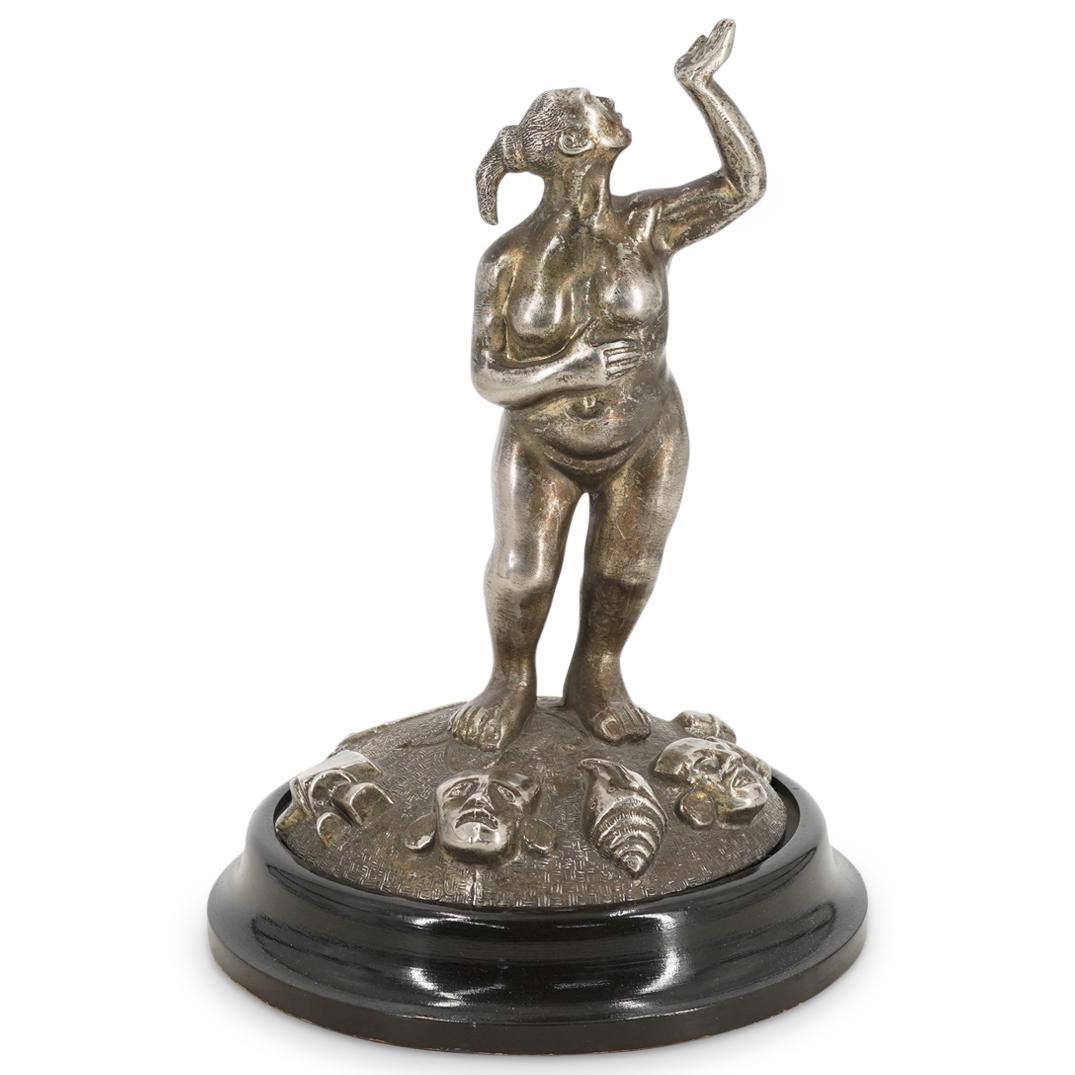 South American Silvered Bronze Figural Statue: DESCRIPTION: A South American figural statue composed of silvered bronze depicting an ancient tribal figural with hand raised high, atop a mask and object adorned base. CIRCA: 20th Cent. ORIGIN: South