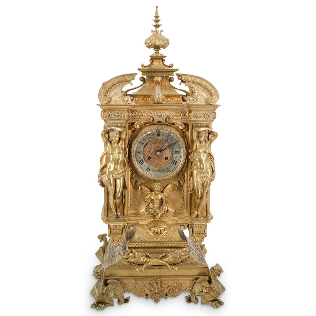 Monumental Tiffany & Co Figural Nude Bronze & Ormolu Mantel Clock: DESCRIPTION: Antique ornate Tiffany & Co bronze clock comprising of four dragon form feet, four masks in relief around the base as well as a sculpture of crossed cornucopias over open work scroll desi