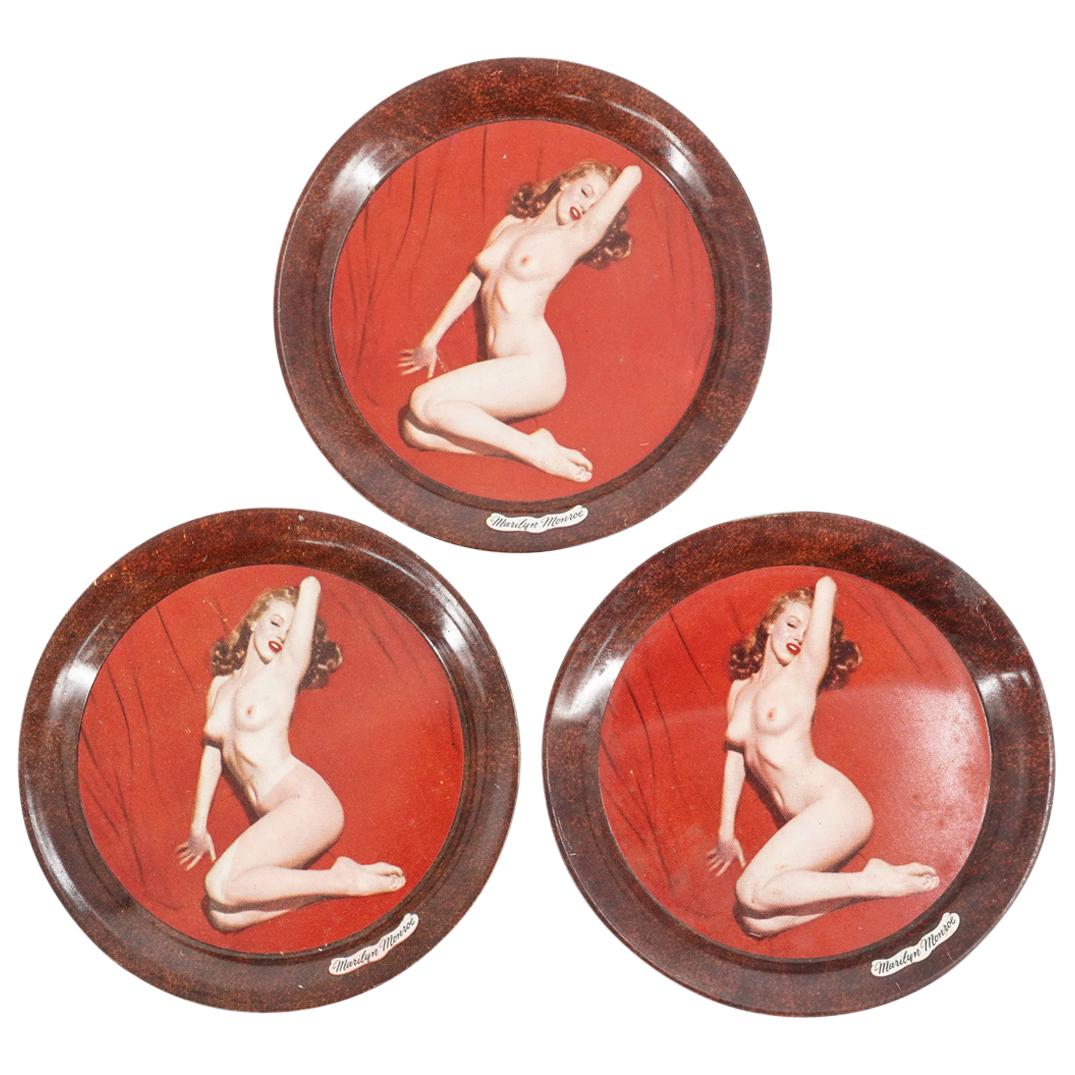 (3 Pc) Vintage Marilyn Monroe Nude Enamel Dishes: DESCRIPTION: Lot of Three Enamel dishes decorated with a nude Marilyn Monroe along the center, with name tag along the edge. CIRCA: 20th Century ORIGIN: USA DIMENSIONS: Diameter: 4" Have a similar ite