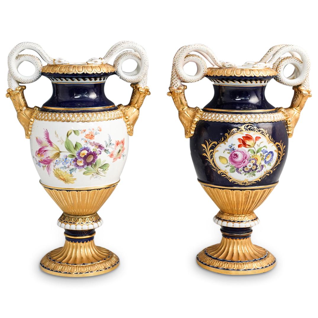 Pair Of Meissen Serpentine Porcelain Urns: DESCRIPTION: A pair of Meissen porcelain urns decorated with alternating cobalt blue and gilt base colors, centered by multicolored floral bouquets, completed along the neck with coiled serpentine han