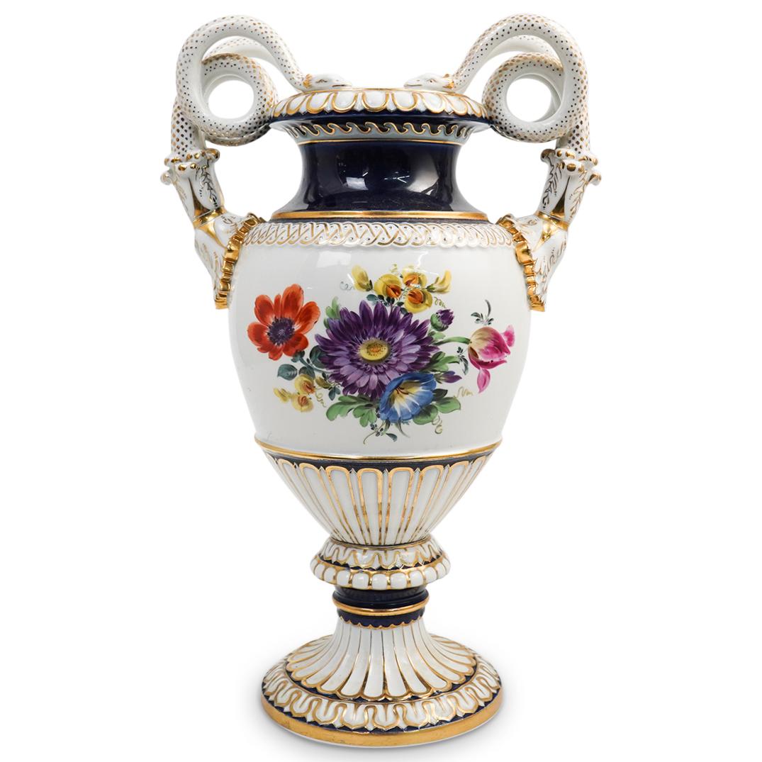 Meissen Serpentine Porcelain Urn: DESCRIPTION: A meissen porcelain urn features floral depictions over a white ground, further decorated with Cobalt blue and gilt accents, completed with coiling serpentine handles. Marked with Meissen