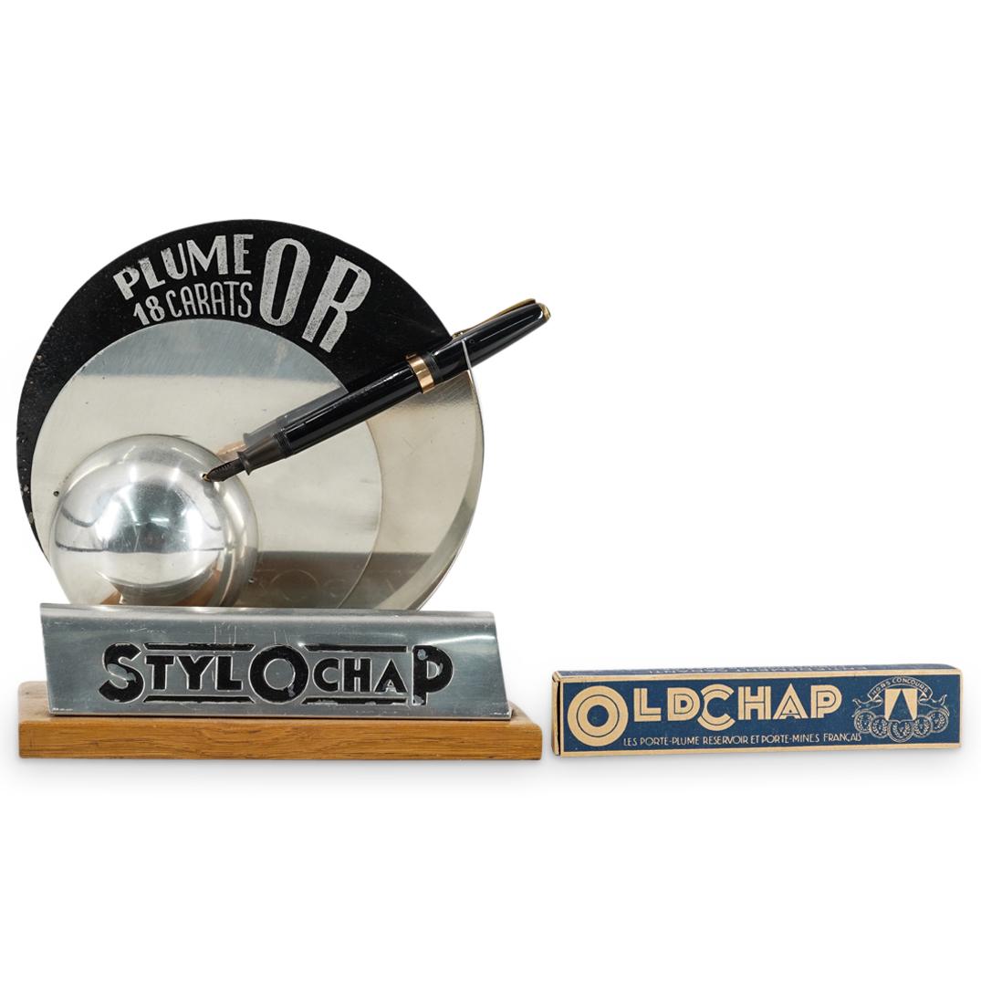 Art Deco Stylochap Pen & Advertising Display: DESCRIPTION: Art Deco Stylochap pen with a solid 18k gold knib and advertising display. Display marked: "Max Tallet Lyre, Stylochap" pen marked: "Grand Prix, Stylochap" includes original pen box. CIRC