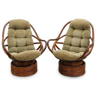 Pair of Paul Frankl Style Rattan Swivel Chairs: DESCRIPTION: Pair of Mid Century Paul Frankl style rattan swivel chairs with high-back egg forms and tufted cushion upholstery, raised on round cylindrical bases. CIRCA: 20th Century ORIGIN: DIMENSION
