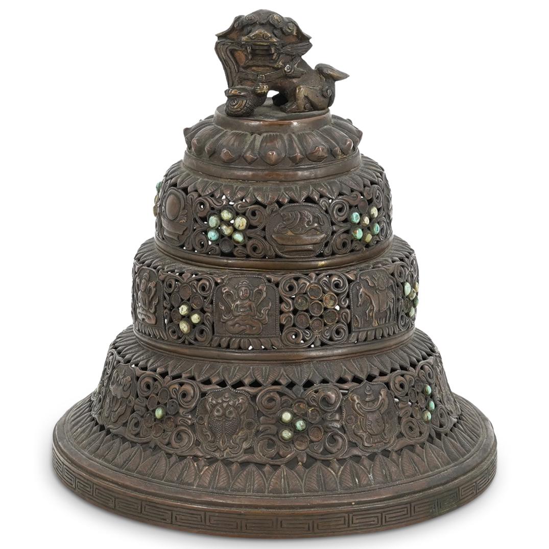 Southeast Asian Bronze Incense Burner: DESCRIPTION: An antique Southeast Asian incense burner with pierced foliate and figural deity design, completed with a foo dog finial. CIRCA: 19th Century ORIGIN: Southeast Asia DIMENSIONS: H: 8" x D: