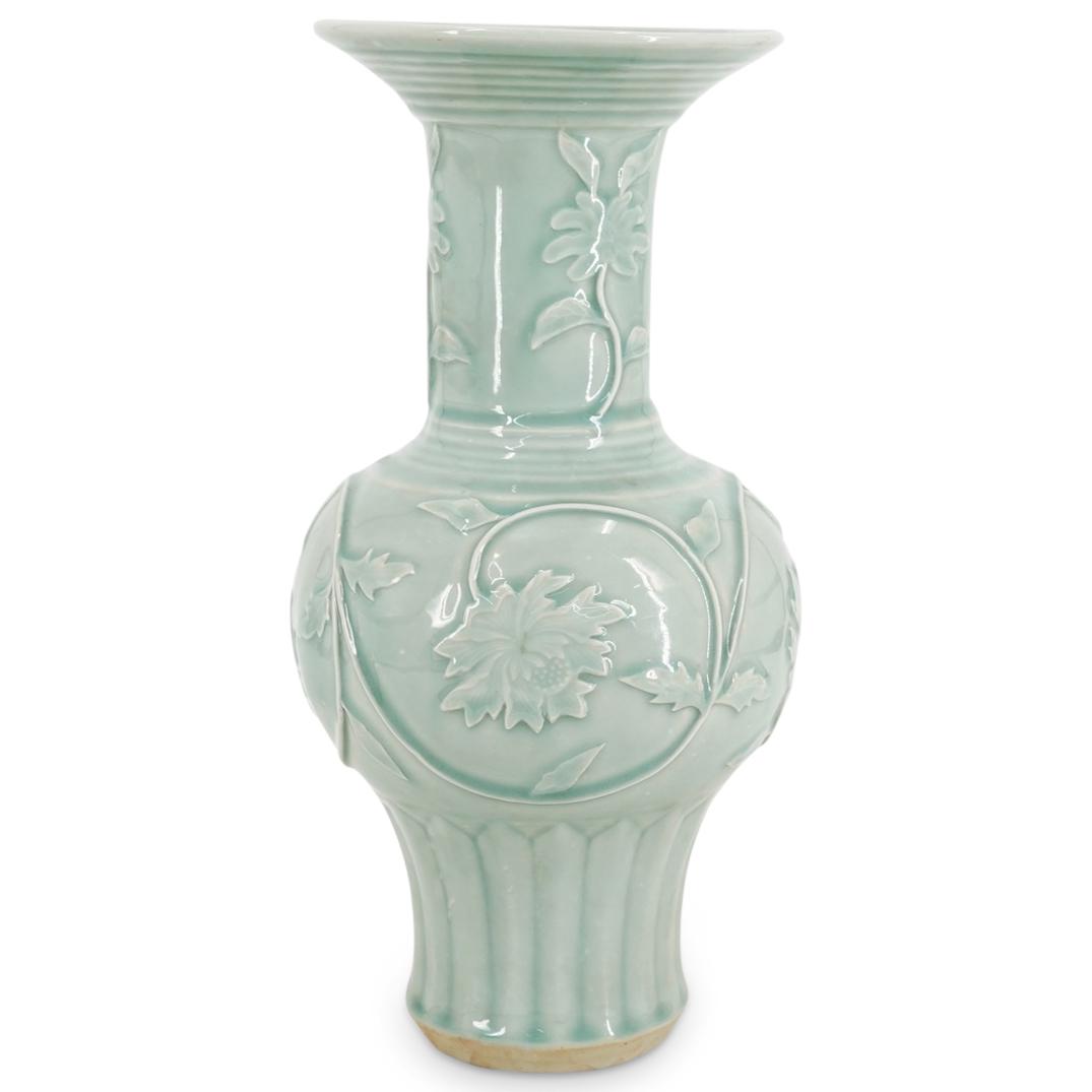 Vintage Chinese Celadon Porcelain Gourd Vase: DESCRIPTION: Vintage porcelain gourd vase featuring a celadon glaze and a flared lip. Piece is decorated with floral and foliage designs in relief and finished with ribbing around the foot. CIRCA: 20t