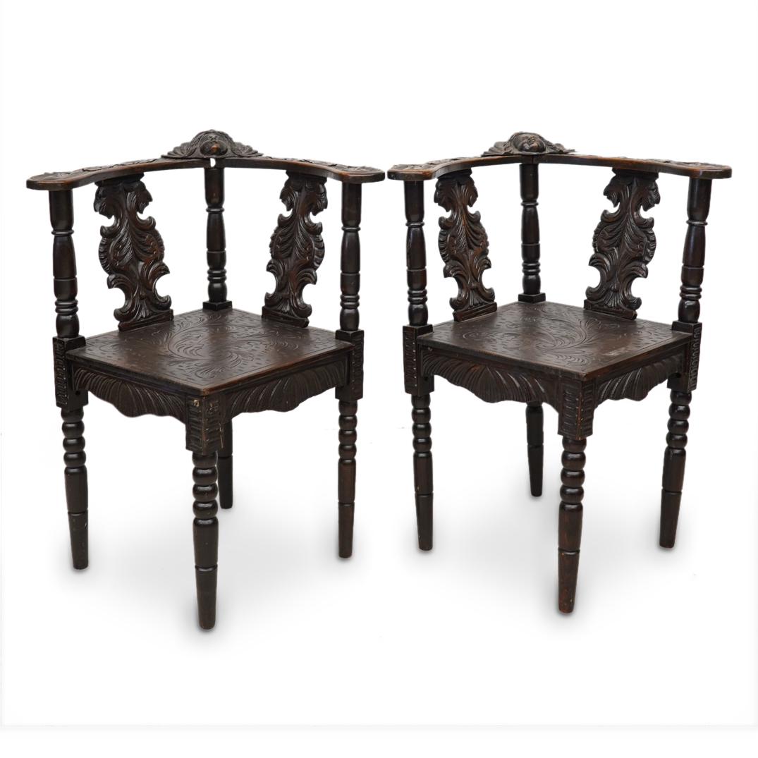 Pair of Spanish Renaissance Carved Wood Corner Chairs: DESCRIPTION: A pair of Spanish Renaissance carved wood corner chairs with figural cherub masks and acanthus leaf details. (Aisel 1 Bay 2) CIRCA: 19th Century ORIGIN: Spain DIMENSIONS: H: 31" x W: 25"