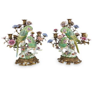 Pair of Bronze Mounted Porcelain Bird Candelabras: DESCRIPTION: A pair of United Wilson bronze mounted porcelain bird group candelabras, each with European styled, three candle holding arms, designed with vibrant painted, tropical quaker parrots