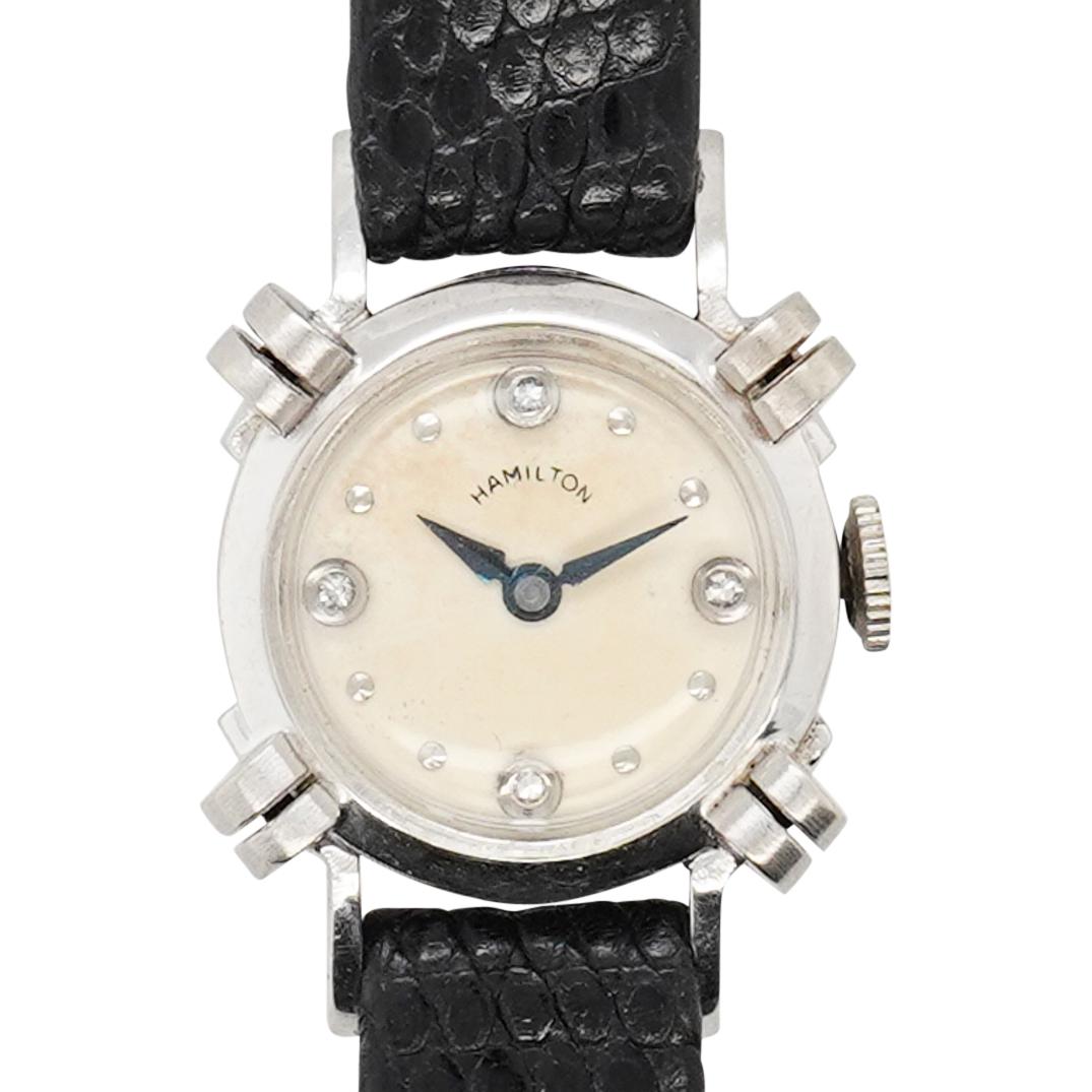 Hamilton Model (911) 14k Gold Diamond Ladies Watch: DESCRIPTION: Hamilton Model (911) 14k white gold ladies watch with diamond inset hour markers, blue hands, and butterscotch toned face. Signed: "Hamilton" movement marked: "Hamilton 911, T23, 1809 17 