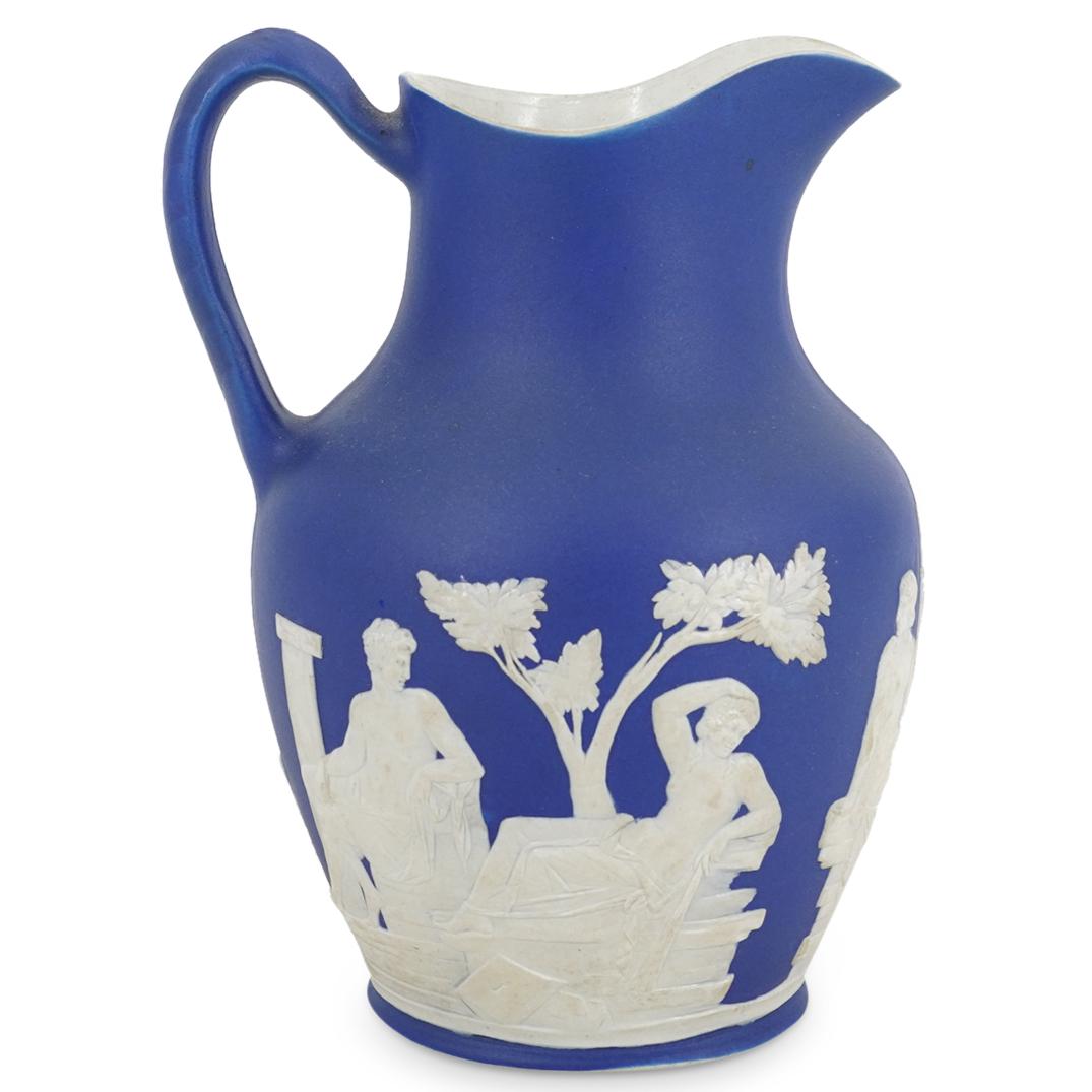 Antique Wedgwood Neoclassical Porcelain Ewer: DESCRIPTION: Wedgwood porcelain ewer featuring white, neo-classical images in relief against a blue background. Imprinted "WEDGWOOD" on underside. CIRCA: 20th Century ORIGIN: England DIMENSIONS: H: 8"