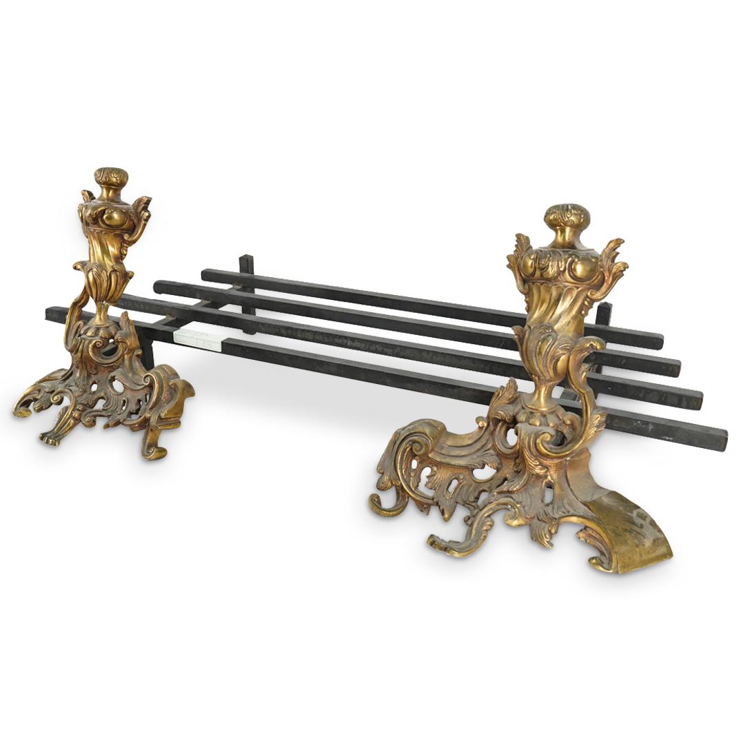 Antique French Gilt Bronze And Iron Andiron W/ Platform: DESCRIPTION: Two gilt bronze andirons attached to a four bar platform for holding firewood. Each andiron is decorated with a foliage and urn form design. CIRCA: Early 20th Century, possibly older ORIG