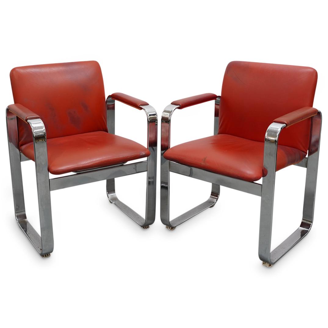 Pair of Vintage Chrome and Leather Chairs: DESCRIPTION: A pair of vintage chairs composed of a chrome frame with curved legs and arm rests, upholstered with vibrant red leather. CIRCA: late 20th Cent. ORIGIN: USA DIMENSIONS: H: 32" W: 24" Dept