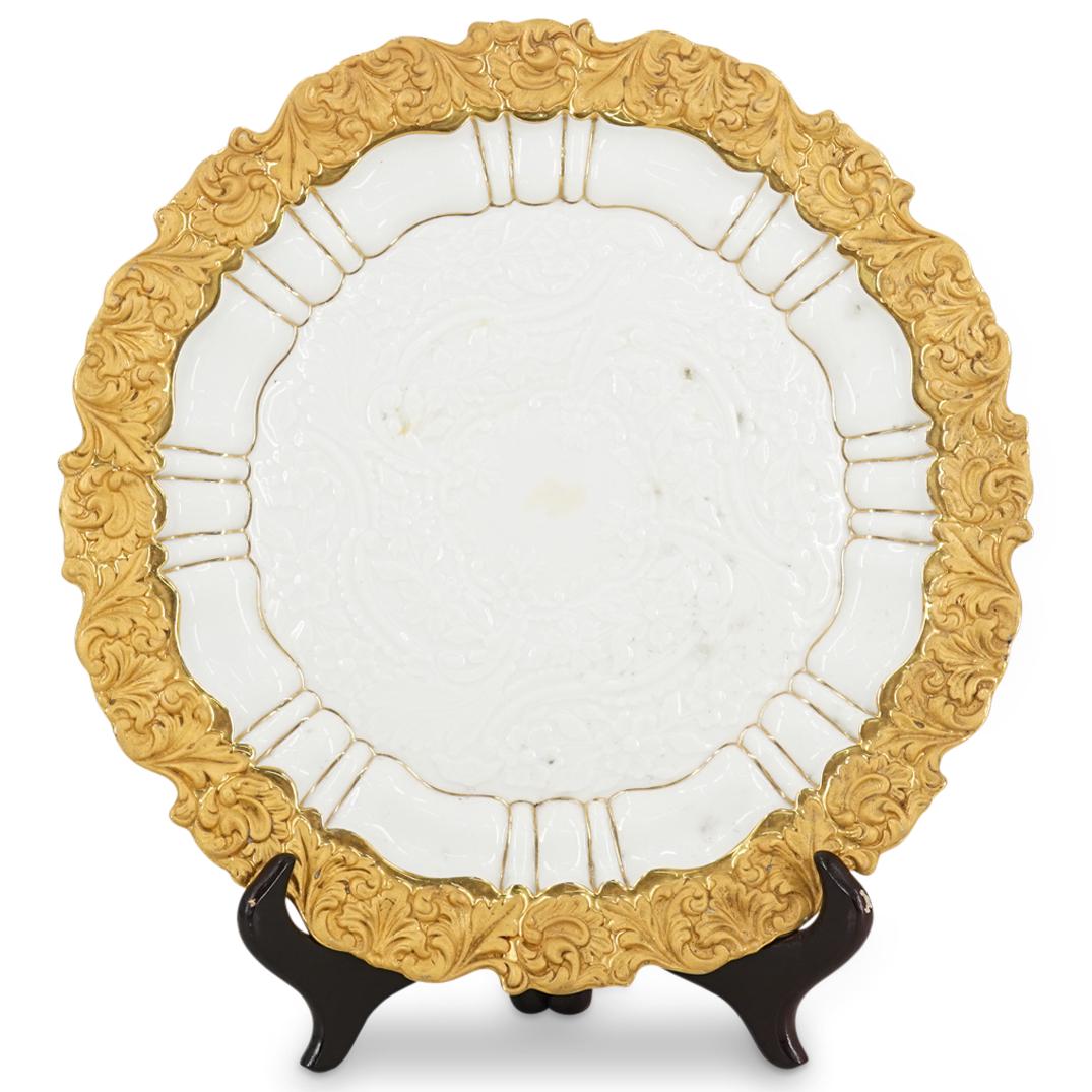 Antique Meissen Parcel Gilt Porcelain Plate: DESCRIPTION: Antique Meissen porcelain plate featuring parcel gilt foliate scroll designs around the rim, foliage depictions in relief in the well and further details of petal form around the well gil