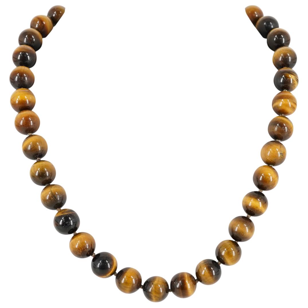 Tiger Eye Round Beaded Necklace: DESCRIPTION: A 17 1/2" long tiger eye round beaded necklace. Tiger eye beads are 1/2" wide. CIRCA: 20th Century DIMENSIONS: L: 17 1/2" Have a similar item to sell? Contact: Info@Akibaantiques.com. CON