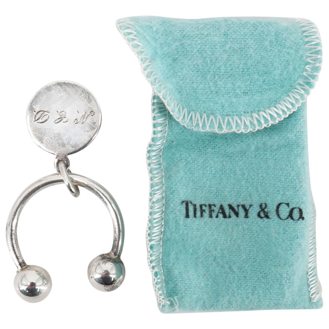 Tiffany And Co Sterling Silver Keychain: DESCRIPTION: Tiffany & Co sterling silver keychain featuring a charm monogrammed "N.C.D." Charm hallmarked on verso: "STERLING TIFFANY & CO". CIRCA: 20th Century ORIGIN: USA DIMENSIONS: H: 1.25" W: 1.