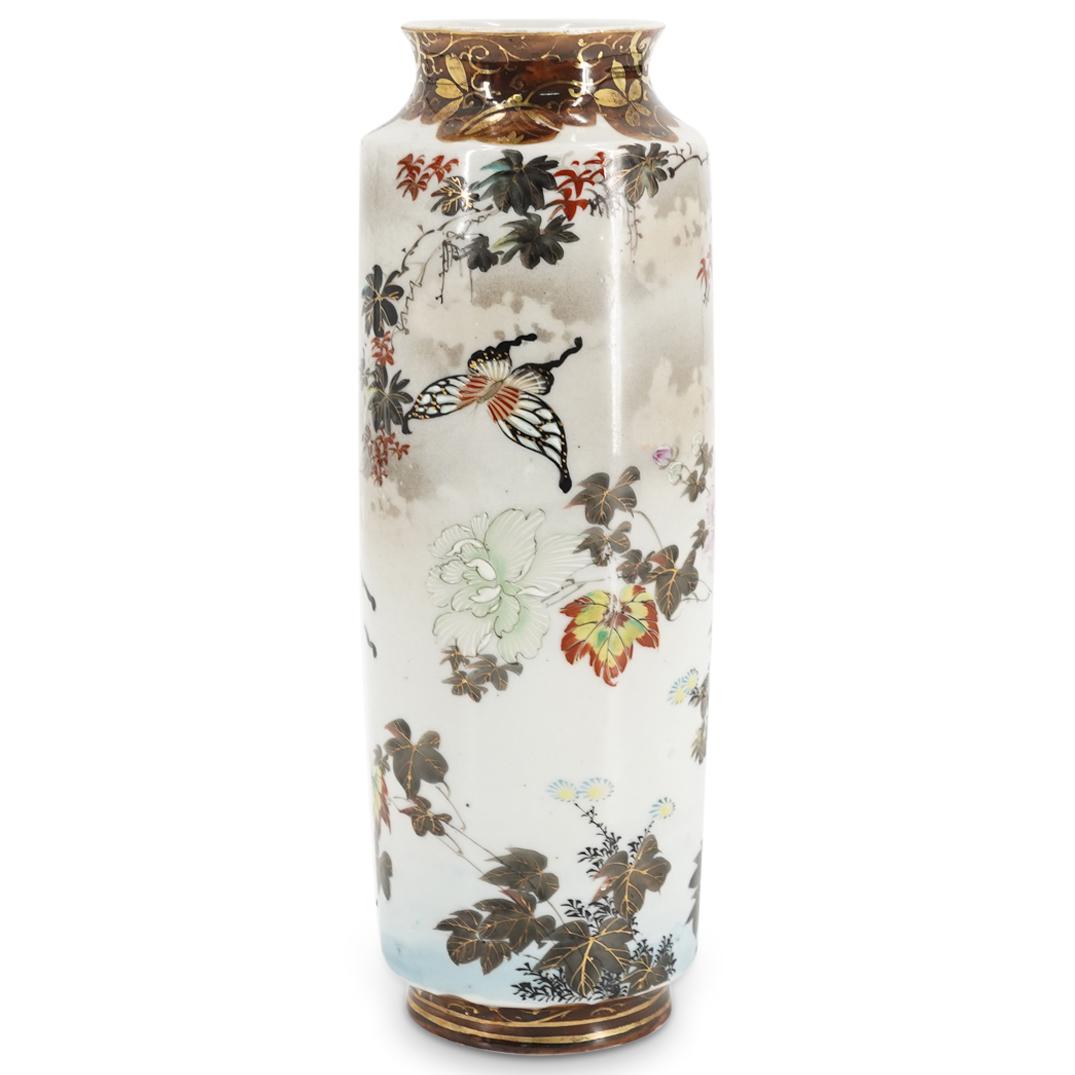 Antique Japanese Kutani Porcelain Vase: DESCRIPTION: An antique Japanese Kutani porcelain vase with cylindrical form, and tapered neck, decorated with butterfly and blossoming flower depictions. Character markings in red at underside. CIRCA