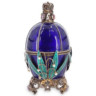 Austrian Empire Gilt Silver Enameled Egg: DESCRIPTION: Austrian Empire style gilt silver egg with sapphire blue enameled body surrounded by applied green enameled foliate and hanging pearl details. Opens at mid-section to reveal gilt etched i