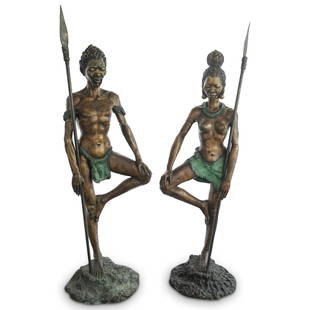 Pair of Bronze African Warrior Sculptures: DESCRIPTION: A pair of bronze sculptures of African warriors standing at attention: one a man wearing a front covering loincloth and marked on his face, chest, and arms; one a woman donning a skirt an