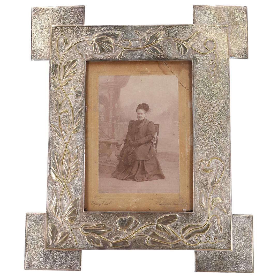Antique Silver Plated Frame W/ Antique Monochrome Photo: DESCRIPTION: Photographic paper backing marked "Verza and Curolo" (in Spanish) and "Florida 165. Buenos Aires". CIRCA: 20th Century ORIGIN: South America DIMENSIONS: (Frame) H: 16" W: 1" L: 13.25" (Ph