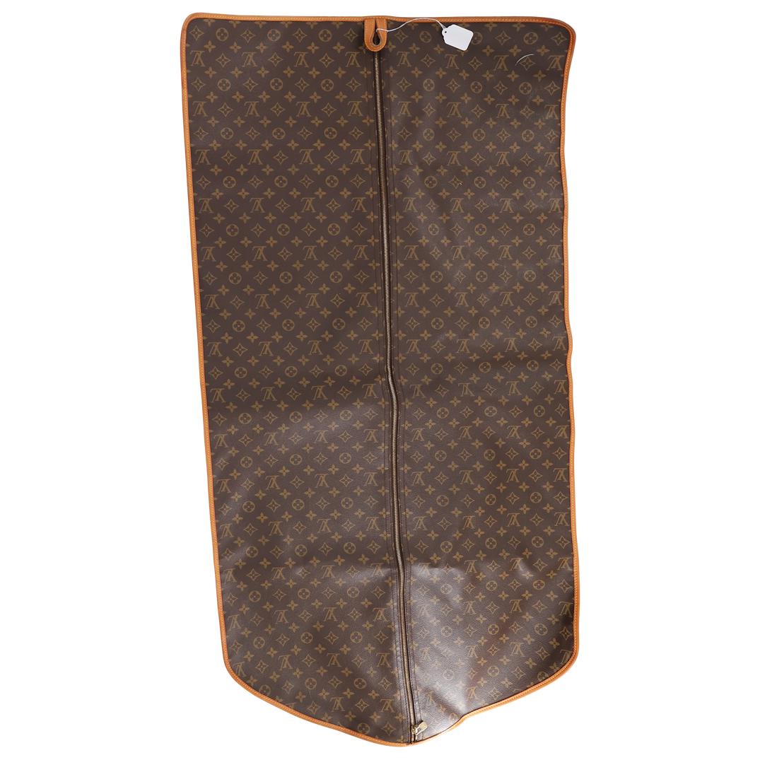 Vintage Louis Vuitton French Company Garment Bag: DESCRIPTION: Louis Vuitton French Company, designed as a simple single compartment hanging garment bag composed of classic monogram canvas with caramel colored leather trim to the edges lined in typic