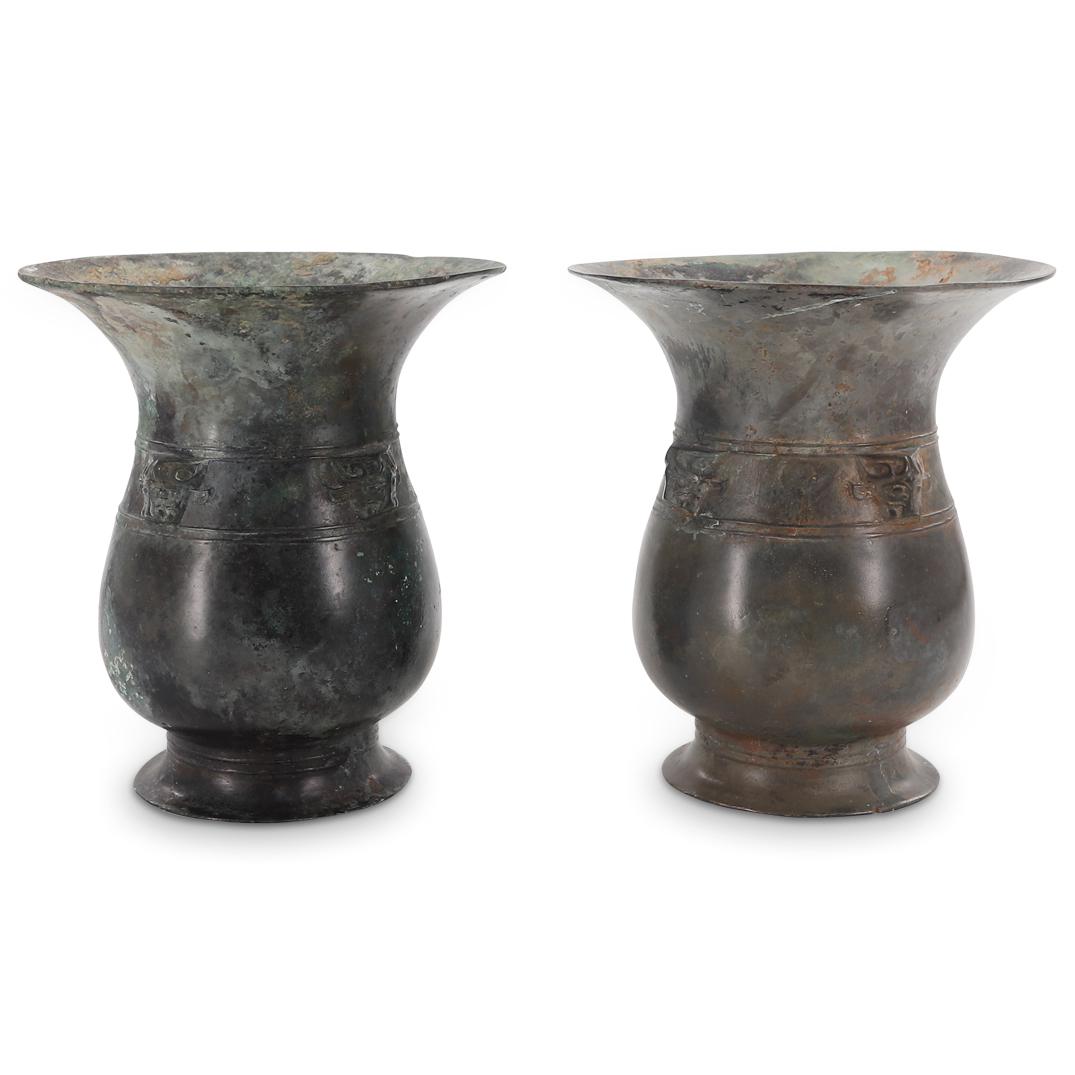 Pair Of Ancient Chinese Western Zhou Zun Ritual Wine Vessels: DESCRIPTION: Two ancient Western Zhou dynasty zun drinking goblets, each featuring a flared foot, a pear shaped body, and a flared lip. Each piece is decorated with a frieze of two rows of double line
