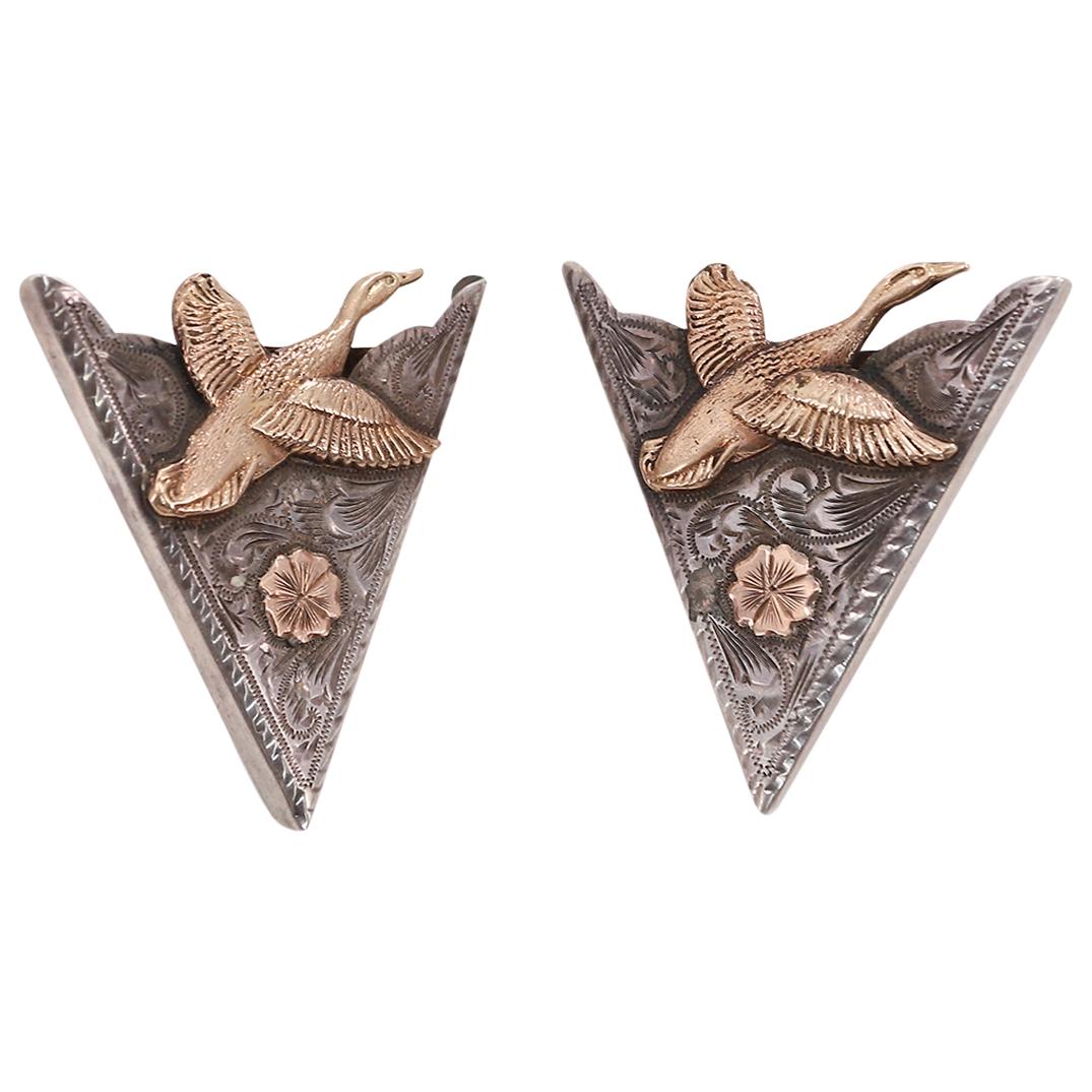 (2Pc) The Westerner Sterling Silver & 10k Gold Belt Tips: DESCRIPTION: (2Pc) The Westerner Sterling silver belt end tips featuring engraved scrollwork throughout and 10k gold depiction of a swan and a flower in relief. Impressed at the undersides "The Wester