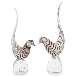 (2Pc) Pair of Murano Glass Striped Bird Sculptures: DESCRIPTION: (2Pc) Pair of clear Murano glass sculpture depicting minimalist style birds with long curving tails and silver fleck and mauve striping throughout. CIRCA: Mid 20th Century ORIGIN: