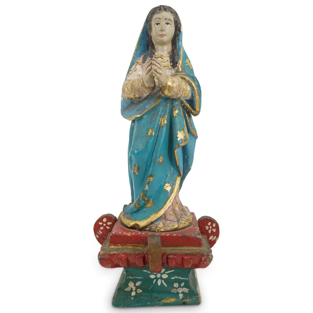 Mexican Carve Wood Painted Madonna Icon: DESCRIPTION: Carved wooden icon depicting Mary standing on a horned, polychrome altar and wearing a red dress beneath a blue, hooded cloak. Piece is embellished with gilt accents throughout and marked