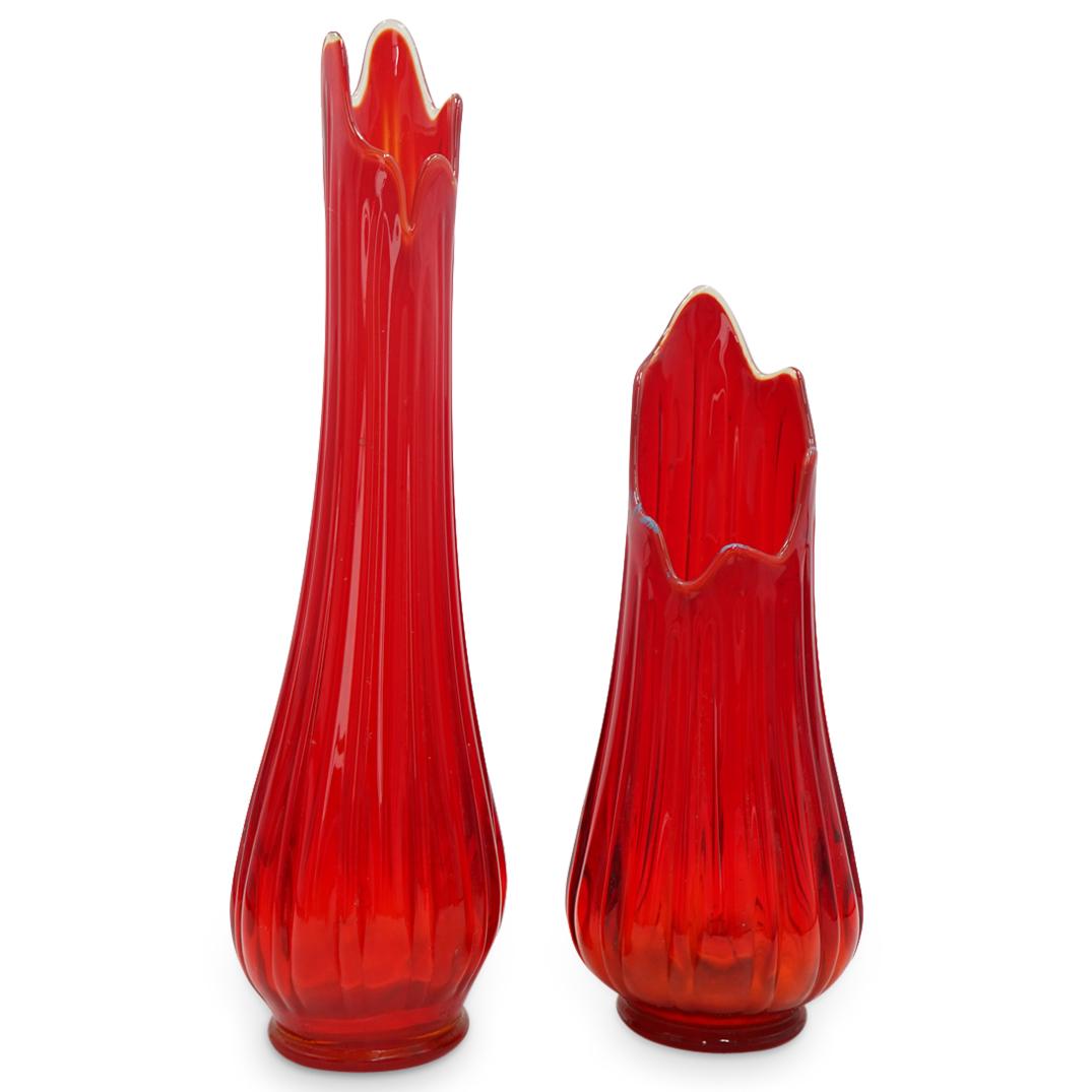 Pair Of Large Red Ribbed Art Glass Vases: DESCRIPTION: Two matching art glass vases-one shorter, one taller-featuring red tones beneath a clear, ribbed exterior. Each piece is finished with a polished, undulating lip of varying height and a r