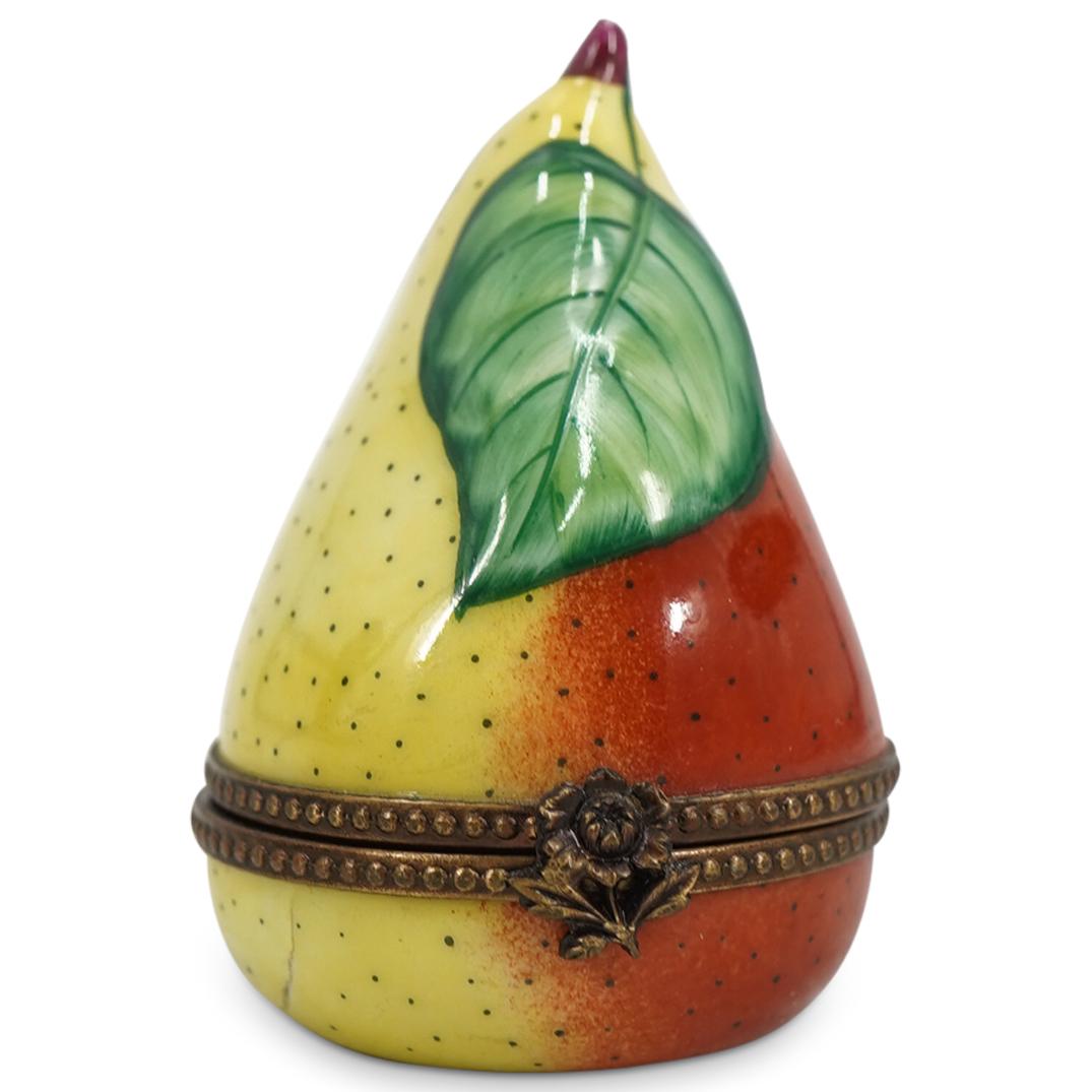 Limoges Porcelain Painted "Pear" Trinket Box: DESCRIPTION: A Limoges porcelain trinket box depicting a pear fruit painted in orange and yellow colors, with green leaves. Marked on the interior with "Limoges France" signature hallmarks. CIRCA: 20t