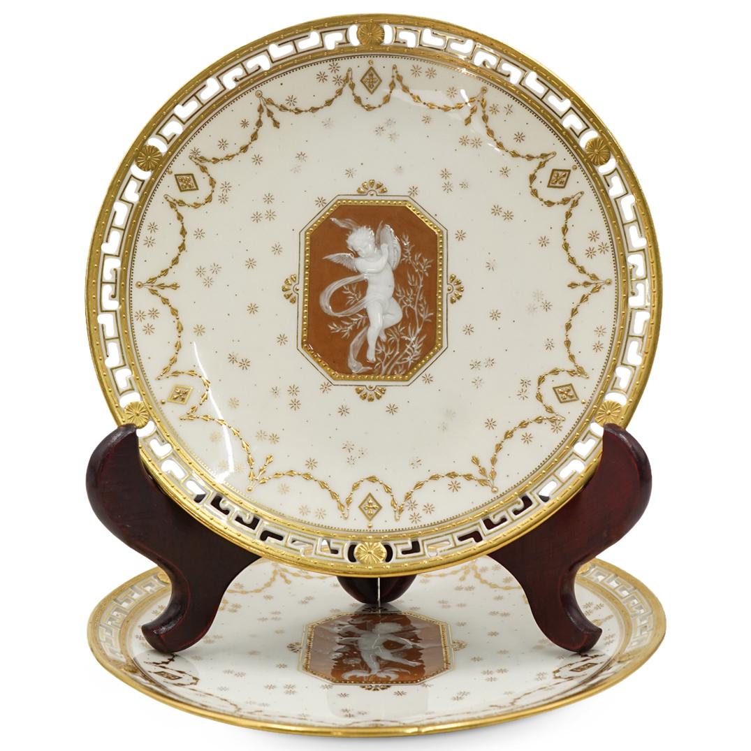 Pair of Mintons Reticulated Pate de Verre Porcelain Plates: DESCRIPTION: Antique pair of Alboin Birks Mintons porcelain plates featuring a parcel gilt rim with a reticulated meandering key pattern, a pate de verre depiction at the center of a putto with birds,