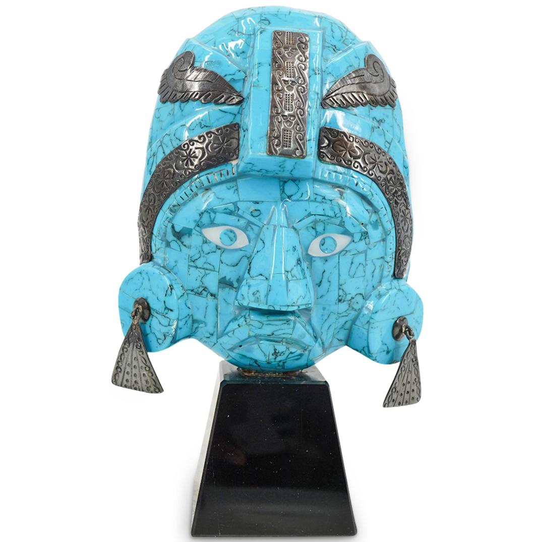 Vintage Mexican Turquoise And Sterling Silver Mask Sculpture: DESCRIPTION: Mayan style turquoise sculpture of a mask featuring silver earrings and applications etched with floral and geometric designs. Piece is mounted on a black, hard stone base. CIRCA: 20th Ce