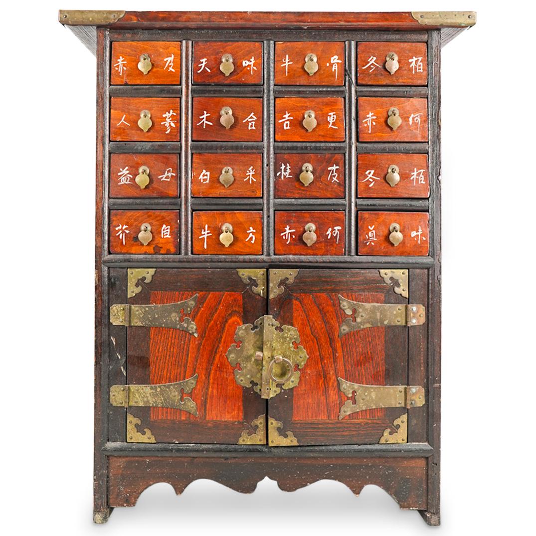 Antique Chinese Carved Wood Apothecary Cabinet: DESCRIPTION: Carved wood apothecary cabinet featuring sixteen drawers, each marked with a pair of Han characters and decorated with a peach shaped, brass pull. Piece is embellished with two doors armo