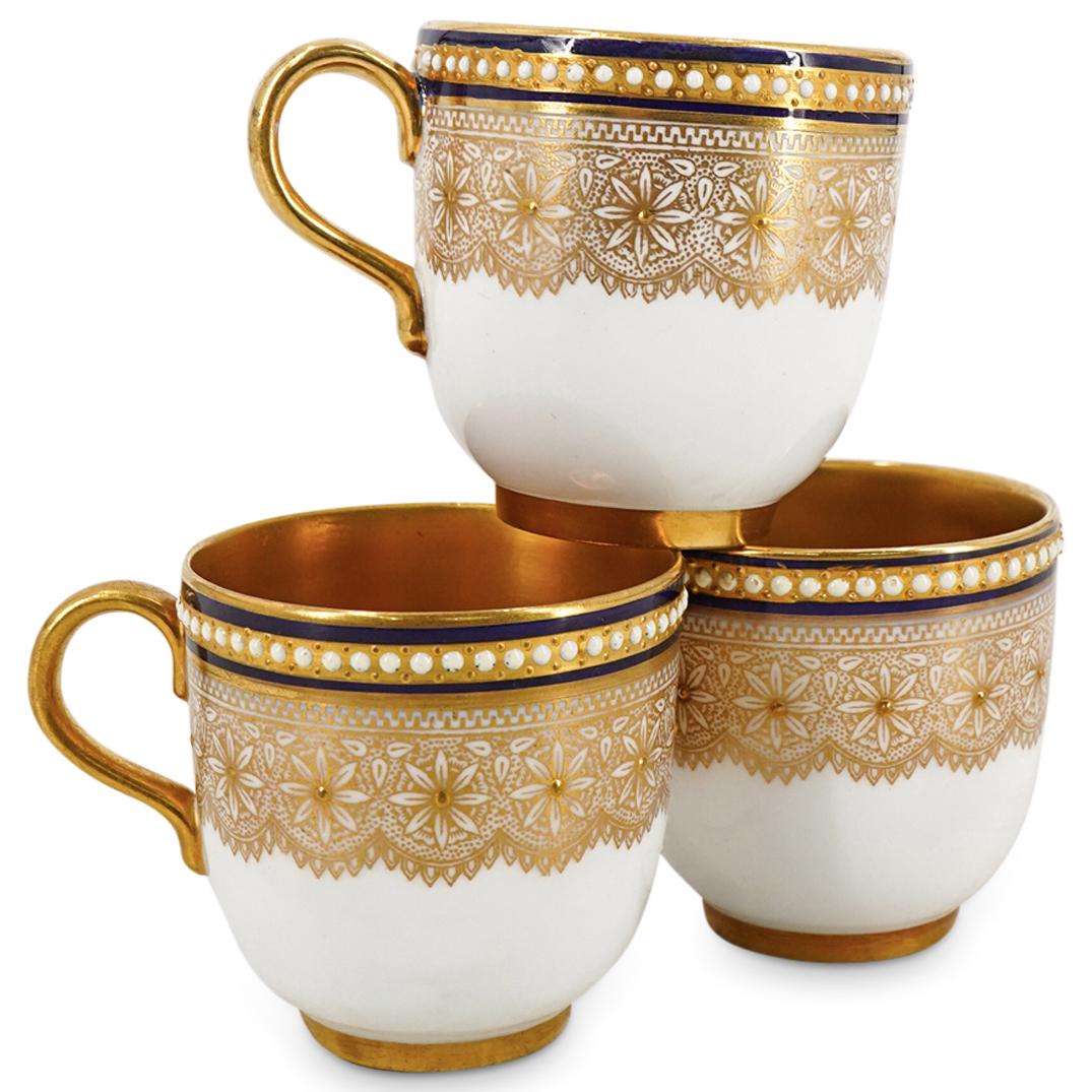 (3Pc) Antique Royal Worcester Gilt Porcelain Teacups: DESCRIPTION: (3Pc) Antique Royal Worcester tea cups featuring parcel gilt loop handles and interiors, gilt floral pattern around the exterior rim accompanied by dark blue bands with white gem enamelin
