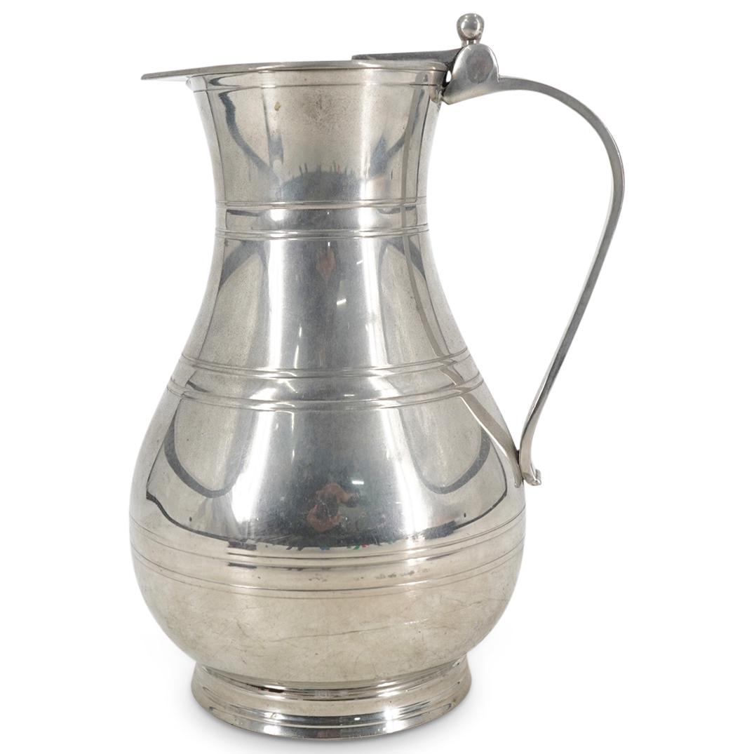 Vintage Cartier Pewter Teapot: DESCRIPTION: Vintage Cartier pewter teapot presenting a round beveled foot, fluted band designs around the body, a hinged lid with a tab atop the scroll handle. Impressed at the underside "English Pew